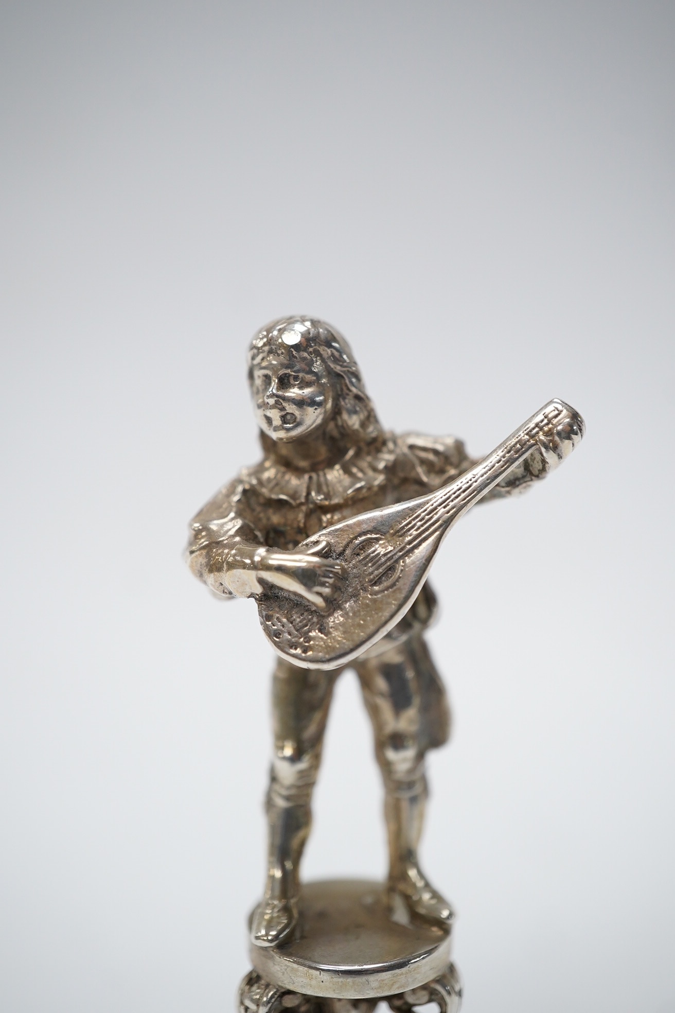 An early 20th century German 800 standard figural desk seal, modelled as a musician, 68mm. Condition - fair to good